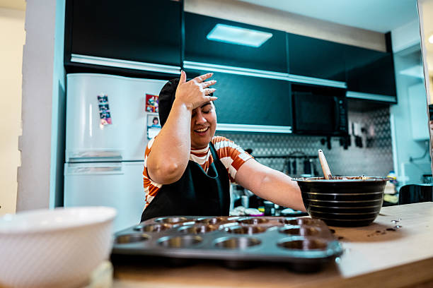 Displeased mid adult woman preparing cake in kitchen